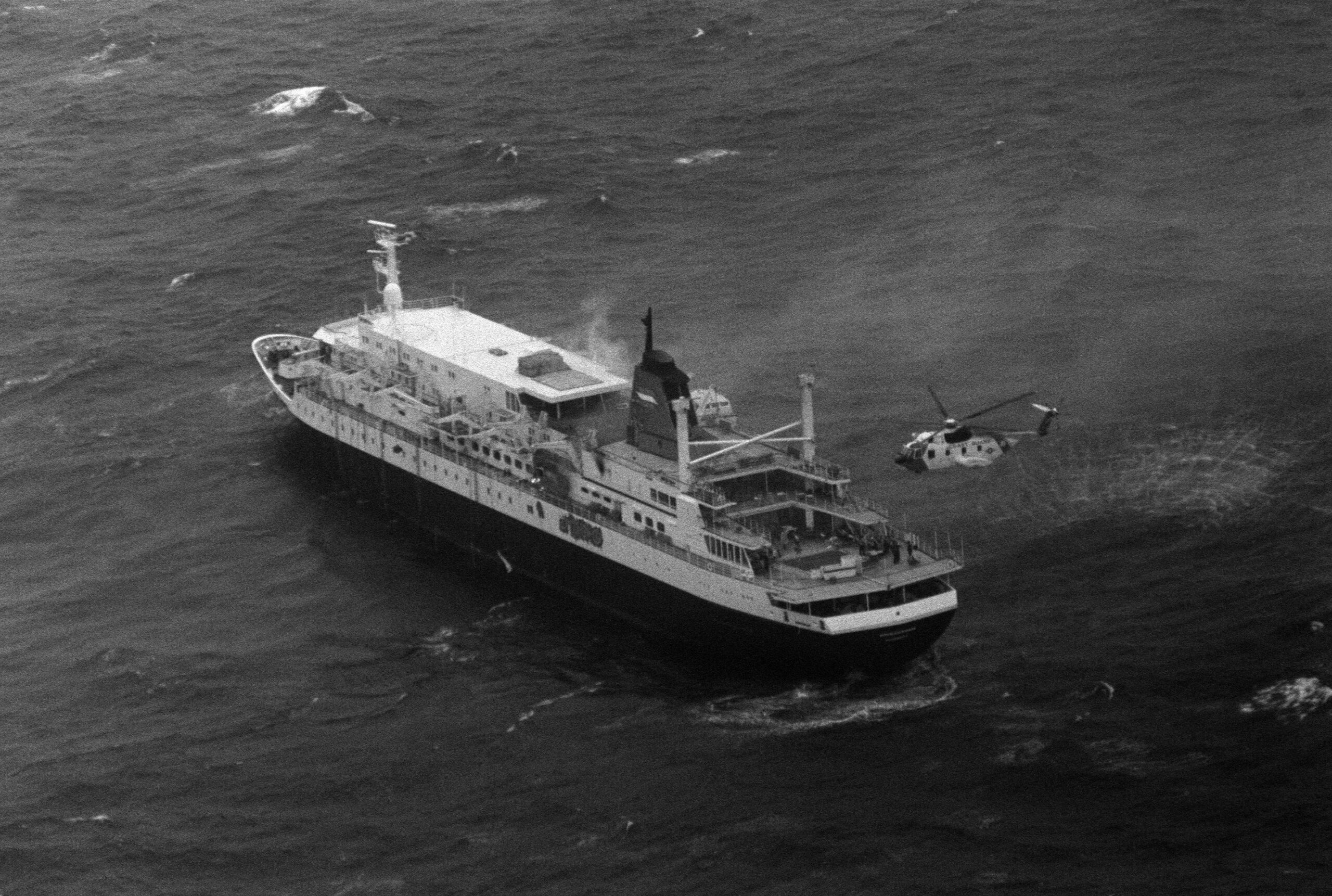 A U.S. Coast Guard HH-3F helicopter beside the burning cruise ship Prinsendam