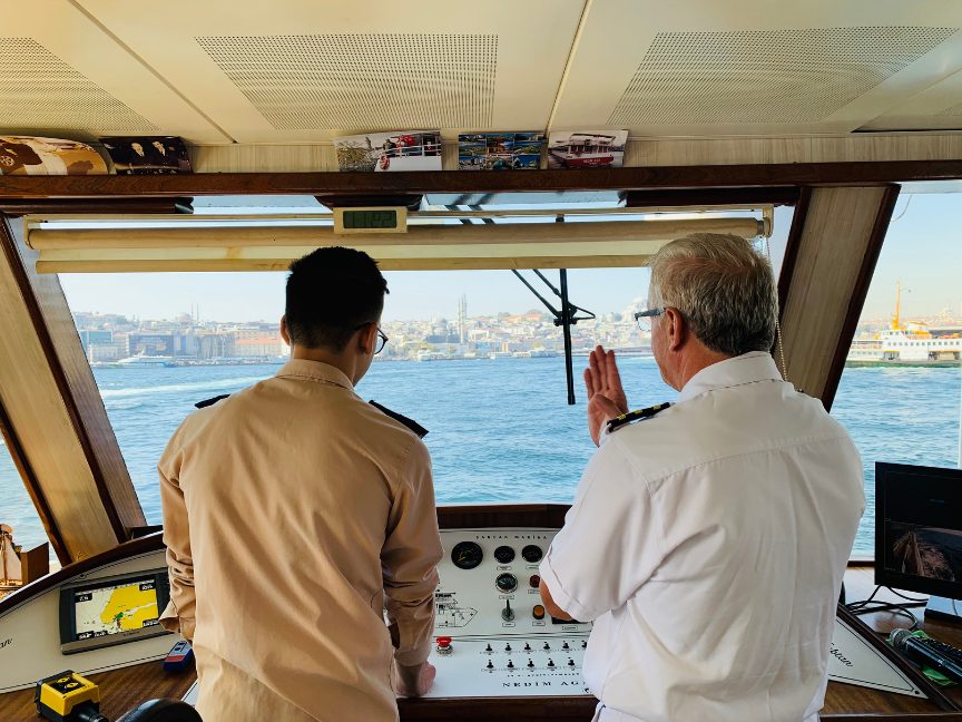 Two officers in conversation on a ship’s bridge
